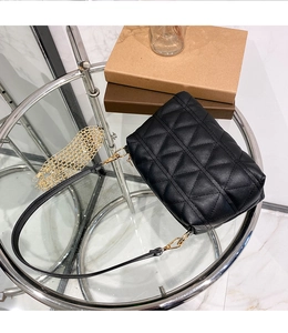 Détail du sac bandoulière noir matelassé avec chaîne dorée et fine lanière cuir