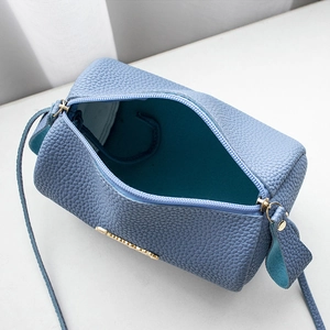 Light blue lychee pattern cylindrical crossbody bag with gold metal plaque and top zipper