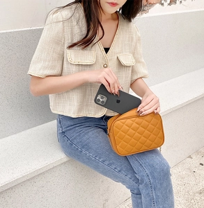 Detail der orangefarbenen Stepptasche mit Platz für ein Smartphone im Inneren