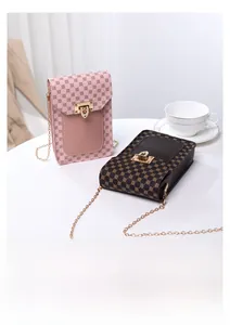 Detail of vintage patterned mini chain bags with gold rotary clasps on a white table