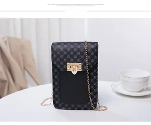Detailed view of women's mini chain bag with black printed pattern and gold clasp