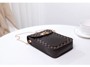 Detail of vintage mini crossbody bag with floral print, gold lock, and chain strap