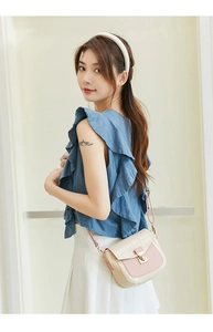 Close-up of a pink and white crocodile pattern crossbody bag with a metal lock