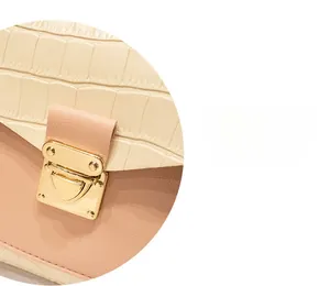 Detailed view of cream crocodile texture and pink leather with gold metal buckle clasp
