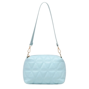Sac bandoulière matelassé bleu clair avec finitions dorées et sangle réglable sur fond blanc