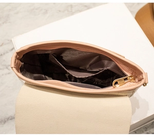 Detail view of the mini crossbody bag interior with brown lining and secure gold zipper