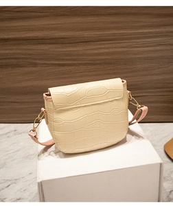 Close-up of creamy white crocodile pattern shoulder bag with gold hardware details
