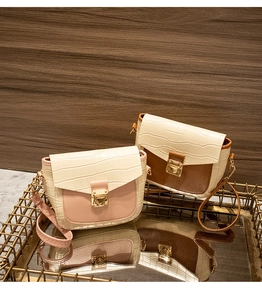 Detail view of mini crossbody bags with crocodile embossed flaps and gold metal locks