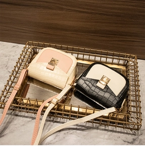Detail of two-tone crossbody bags with crocodile texture and gold square metal buckles