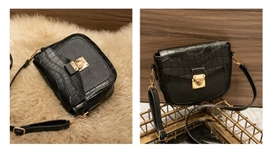 Detail of black faux leather crossbody bag with faux crocodile pattern and gold buckle