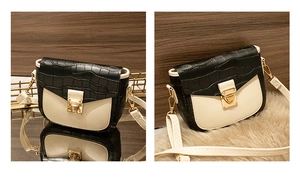 Detail of color-block saddle bag with crocodile texture and gold metal clasp