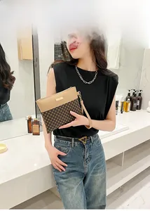 Fashion printed clutch bag with geometric pattern and wrist strap shown by a model