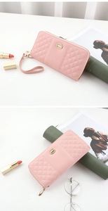 Close-up of pink quilted long wallet with golden logo and detachable wrist strap