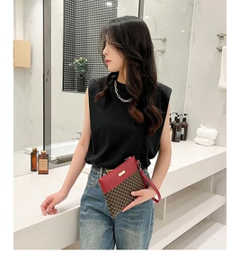 Detail of red leather and brown checkered clutch with gold zipper and wrist strap
