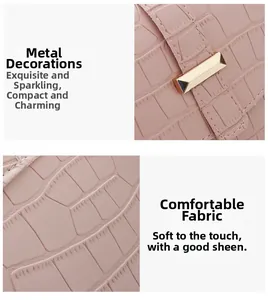 Close-up of pink faux leather saddle bag with crocodile texture and gold hardware