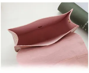 Detail of pink crocodile embossed handbag showing the magnetic clasp and soft interior