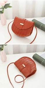 Detailed view of crocodile pattern saddle bag with elegant gold metal buckle clasp