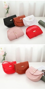 Detail view of colorful faux leather saddle bags with crocodile texture and gold hardware