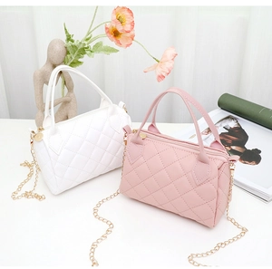 Close-up of quilted pattern bags in white and pink with golden metal chain straps