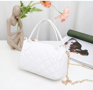 Detailed view of white quilted faux leather handbag with gold chain strap and stitching