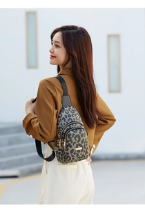 Detail der Crossbody-Tasche mit Leopardenmuster, Doppelreißverschluss und Goldbeschlägen