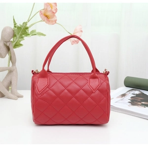 Detailed close-up of red quilted Boston bag with zipper closure and dual top handles