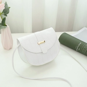 White saddle bag with crocodile pattern and golden buckle on a decorative background