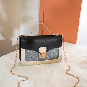 Chic monochrome crossbody bag with starry sequin panel and gold chain strap