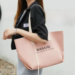 Detailed view of a pink leather tote bag with MIKAXIQI branding and large capacity