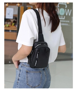 Detalle de bolso de pecho cruzado negro con correa ajustable y logo FITRIGHT estampado