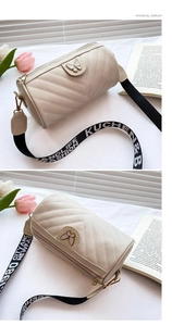 Detail of apricot cylinder bag with V-quilt pattern and butterfly buckle