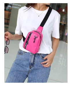 Detalle de bolso bandolera deportivo rosa brillante con correas de letras y estilo moderno