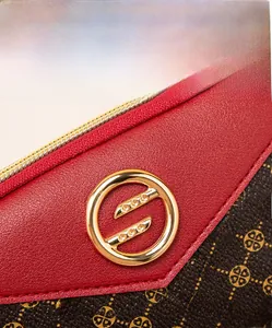 Close-up of red lychee leather and brown floral pattern with gold buckle detail