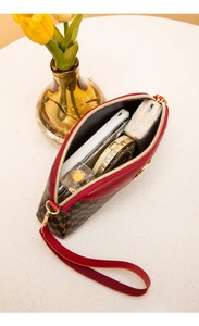 Interior view of red leather trim shell clutch bag showing mobile and cosmetic storage