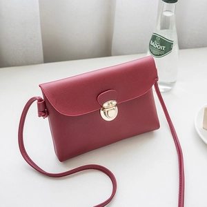 Mini sac bandoulière rouge vin avec fermoir doré et silhouette carrée minimaliste