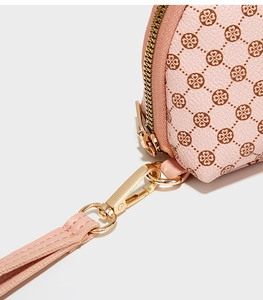 Gros plan du portefeuille en cuir rose avec motifs trèfles et détails dorés