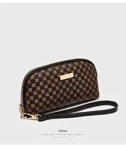 Gros plan du sac en similicuir marron à motif cercle jaune et fermeture éclair dorée
