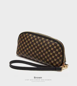 Détail du motif floral jaune sur pochette en similicuir avec fermeture éclair en métal