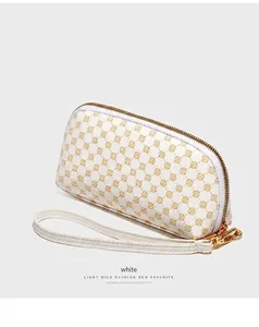 Détail d'une pochette blanche en cuir PU avec motif floral doré et fermeture éclair en or