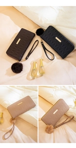 Detail of quilted long wallets for women with golden metal bar and plush pompom charm