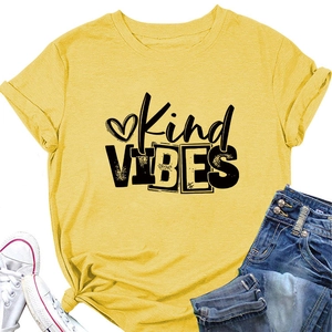 Detail of yellow Kind Vibes t-shirt showing rolled sleeves and side knot with denim jeans