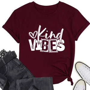 Flat lay of a wine red Kind VIBES t-shirt with heart print and casual accessories