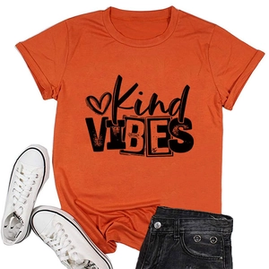 Flat lay of orange cotton T-shirt with Kind VIBES print and heart, styled with white shoes