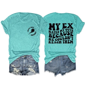 Close-up of light green t-shirt with text graphic paired with distressed denim shorts