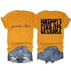 Flat lay of mustard yellow t-shirt with black art text and distressed denim shorts