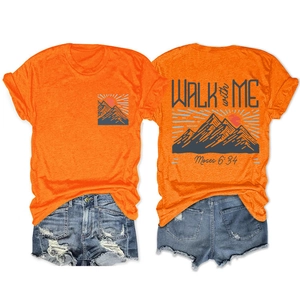 Détail du t-shirt orange à col rond avec motif montagne et short en jean bleu déchiré