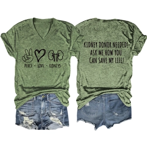 Flat lay of a green V-neck T-shirt with kidney donor message and denim shorts