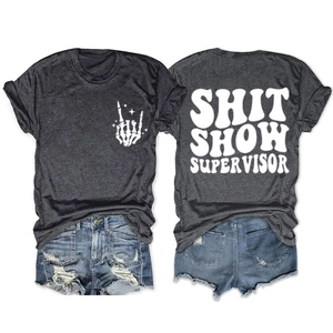 Flat lay of gray T-shirt with Shit Show Supervisor back print and ripped denim shorts