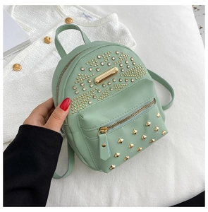 Detail of mint green mini backpack with golden studs and sparkling rhinestones