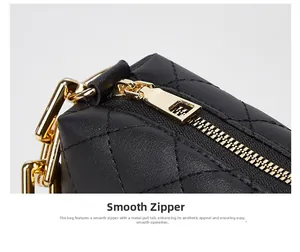 Close-up of golden zipper and hardware on black quilted leather crossbody bag